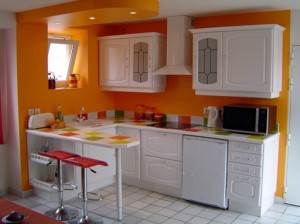 pomarańczowe ściany i białe meble w kuchni